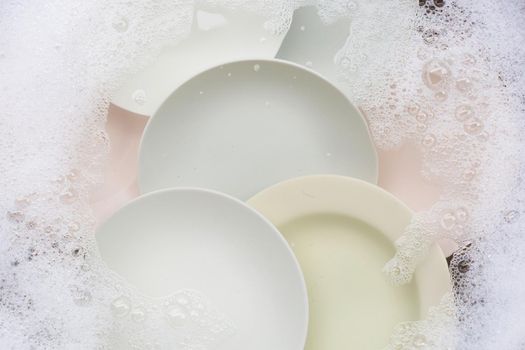Washing dishes, Close up of utensils soaking in kitchen sink.