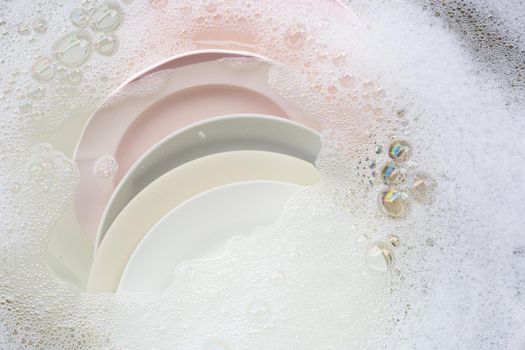 Washing dishes, Close up of utensils soaking in kitchen sink.