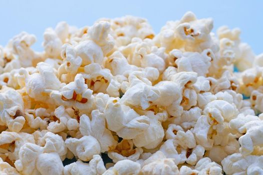 Popcorn on blue background. Copy space