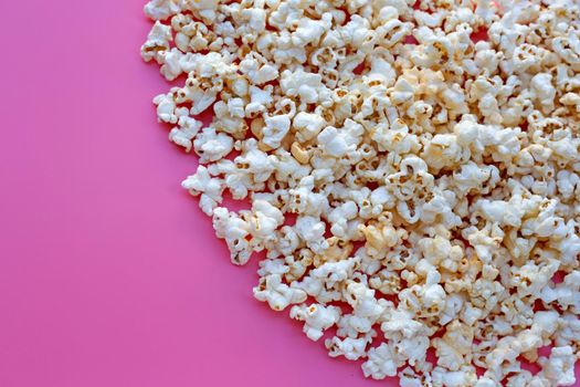 Popcorn on pink background. Copy space