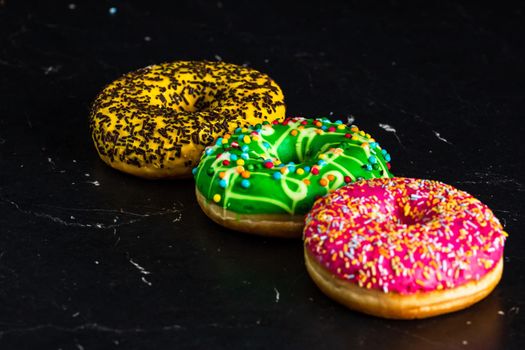 Glazed donuts with sprinkles isolated. Close up of colorful donuts.