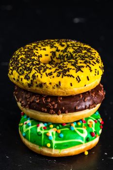 Glazed donuts with sprinkles isolated. Close up of colorful donuts.