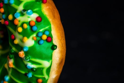 Green glazed donut with sprinkles isolated. Close up of colorful donut.