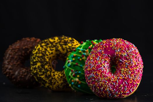 Glazed donuts with sprinkles isolated. Close up of colorful donuts.