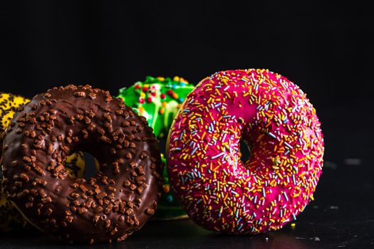 Glazed donuts with sprinkles isolated. Close up of colorful donuts.