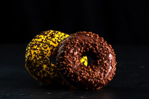 Glazed donuts with sprinkles isolated. Close up of colorful donuts.