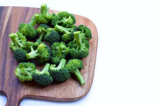 Fresh green broccoli on wooden cutting baound on white background.
