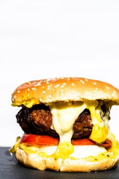 Beef cheeseburger with melting cheese. Tasty homemade cheeseburger isolated on white background.