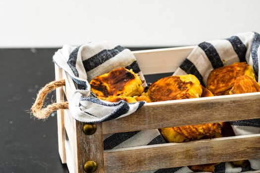 Freshly baked homemade ham and cheese puff pastry in a rustic crate.