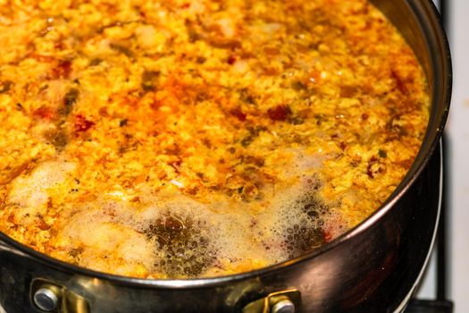 Preparation of soup with chicken and vegetables. Close up of boiling soup.