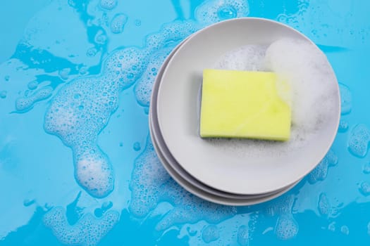 Washing dishes concept on wet blue background. Top view