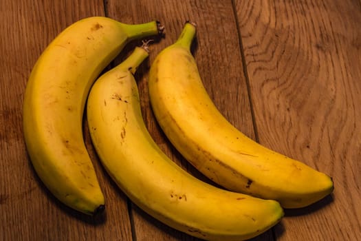 Fresh ripe bananas on a wooden board.