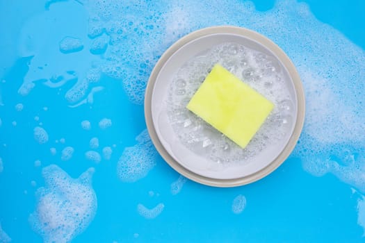 Washing dishes concept on wet blue background. Top view