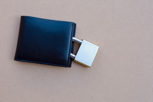 Wallet with padlock on brown background. Copy space