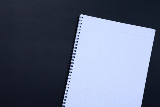 Open notebook on dark background. Top view