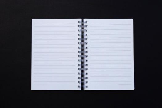 Open notebook on dark background. Top view
