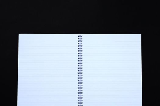 Open notebook on dark background. Top view