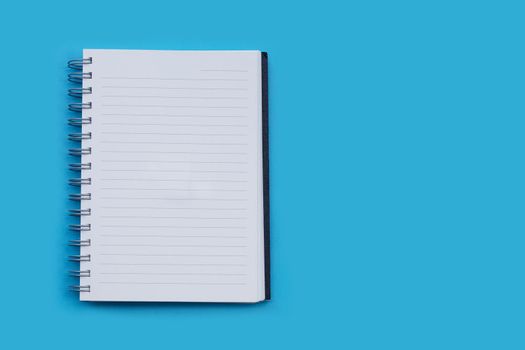 Open notebook on blue background. Top view