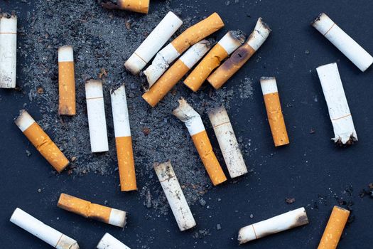 Cigarette butts on dark background.