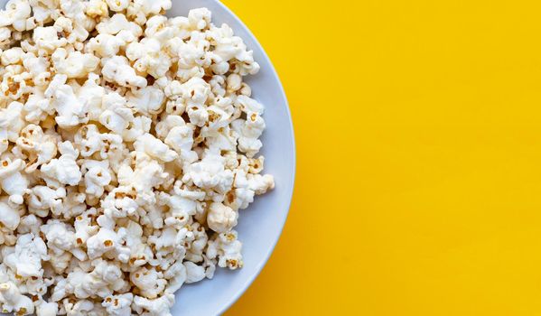 Popcorn on yellow background. Copy space