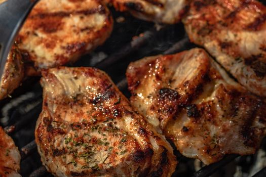 Grilling pork steaks. Delicious meat steaks close up cooking on the barbecue grill