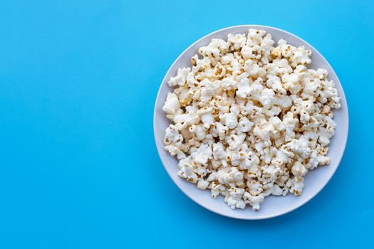 Popcorn on blue background. Copy space