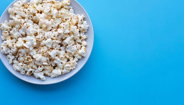 Popcorn on blue background. Copy space