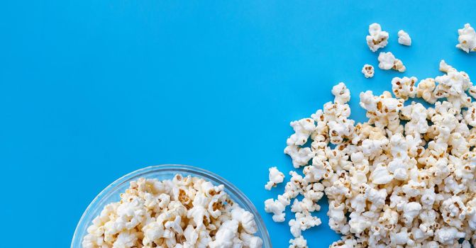 Popcorn on blue background. Copy space