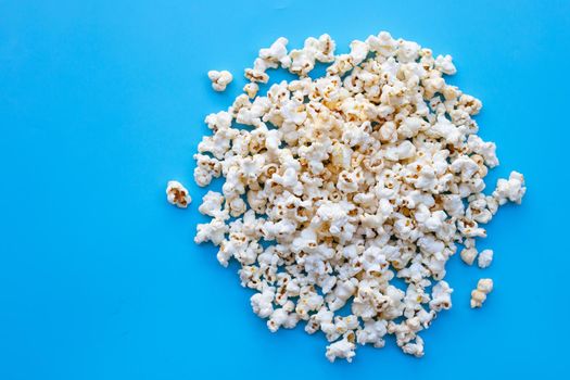 Popcorn on blue background. Copy space