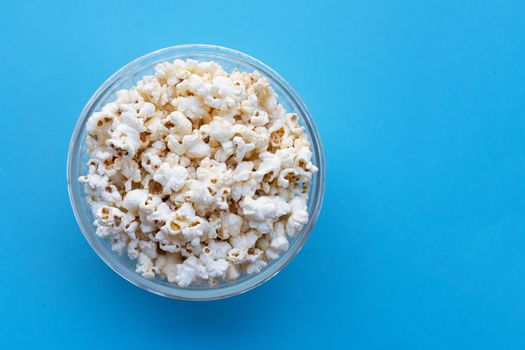 Popcorn on blue background. Copy space