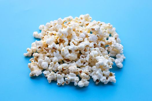 Popcorn on blue background. Copy space