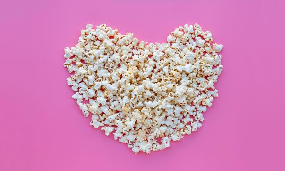 Popcorn on pink background. Copy space