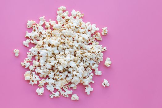 Popcorn on pink background. Copy space