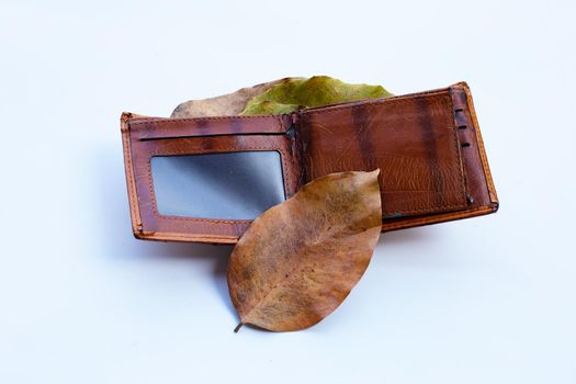 Wallet with dry leaves on white background. Poor or no money concept.