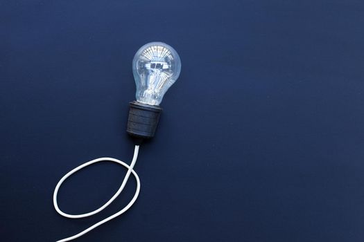 Light bulb on dark background. Ideas and creative thinking concept. Top view