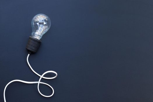 Light bulb on dark background. Ideas and creative thinking concept. Top view