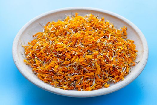 Petals of marigold flower on blue background.