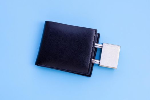 Wallet with padlock on blue background. Copy space