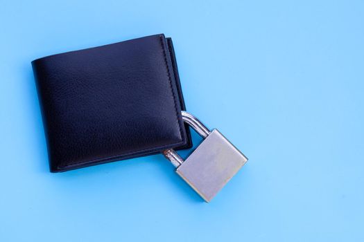 Wallet with padlock on blue background. Copy space