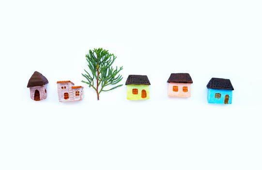 Miniature house with  dragon juniper's leaves (Juniperus chinensis) on white background.