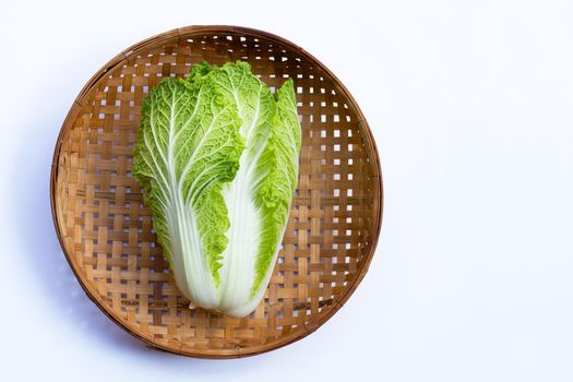 Chinese cabbage in wooden bamboo threshing basket on white background. Copy space