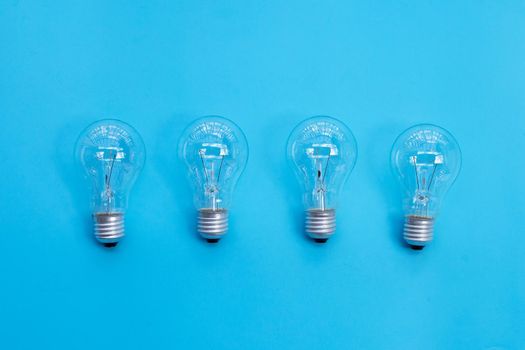 Light bulbs on blue background. Ideas and creative thinking concept. Top view