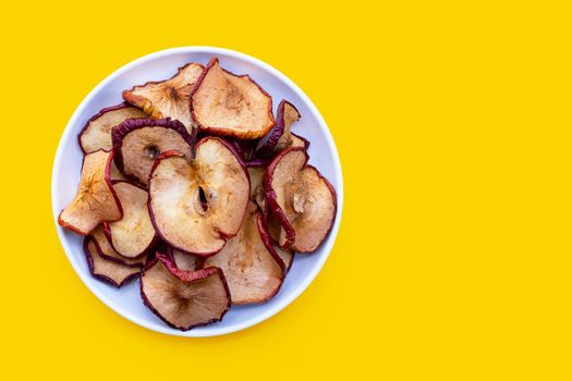 Dried apple slices on yellow background