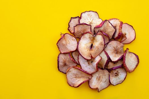 Dried apple slices on yellow background