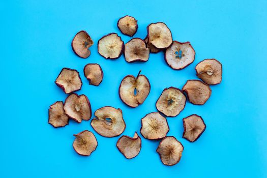 Dried apple slices on blue background