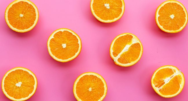 High vitamin C, Juicy and sweet. Fresh orange fruit on pink background.