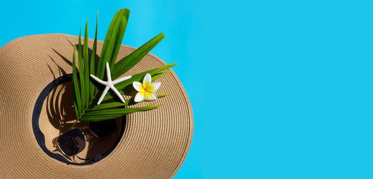 Summer hat with sunglasses on blue background. Enjoy holiday concept. Copy space