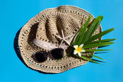 Summer hat with sunglasses on blue background. Enjoy holiday concept. Copy space