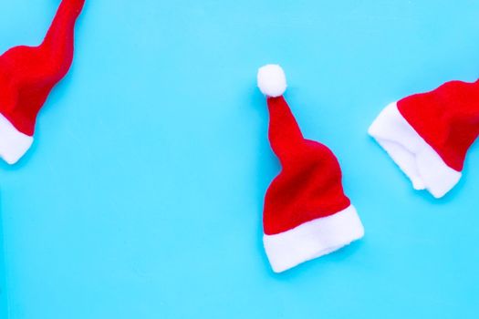 Santa hats on blue background. Copy space
