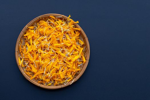 Petals of marigold flower on dark background.